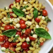 pasta salad with fresh cherry tomatoes, mozzarella pearls and fresh basil.