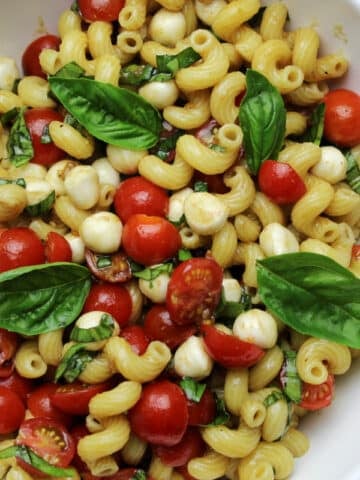 pasta salad with fresh cherry tomatoes, mozzarella pearls and fresh basil.