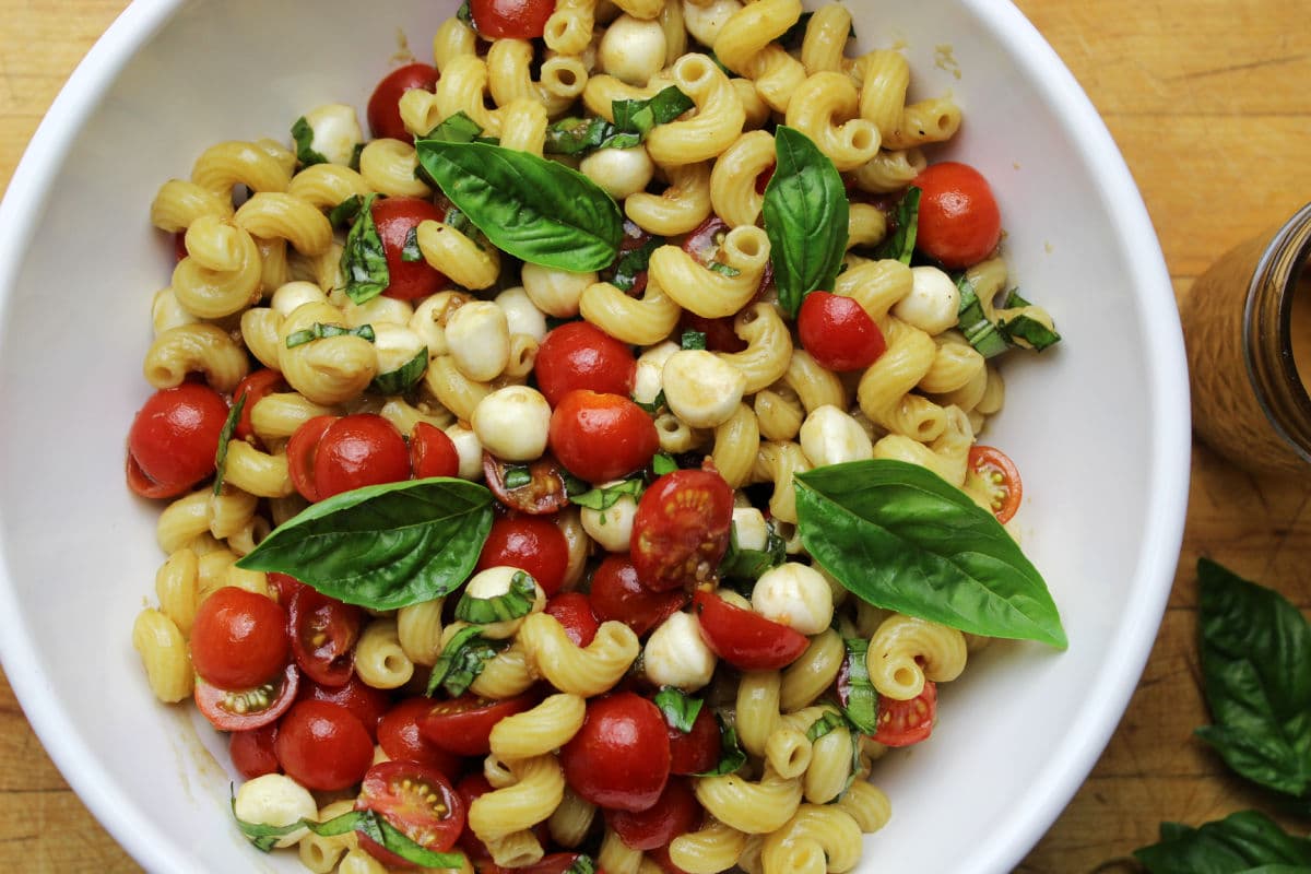 pasta salad with fresh cherry tomatoes, mozzarella pearls and fresh basil.