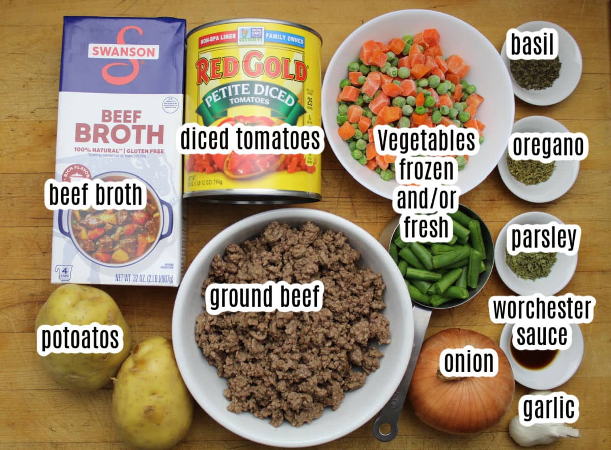 Labeled ingredients for hamburger soup including ground beef, vegetables, beef broth, diced tomatoes, potatoes, onions and seasonings.