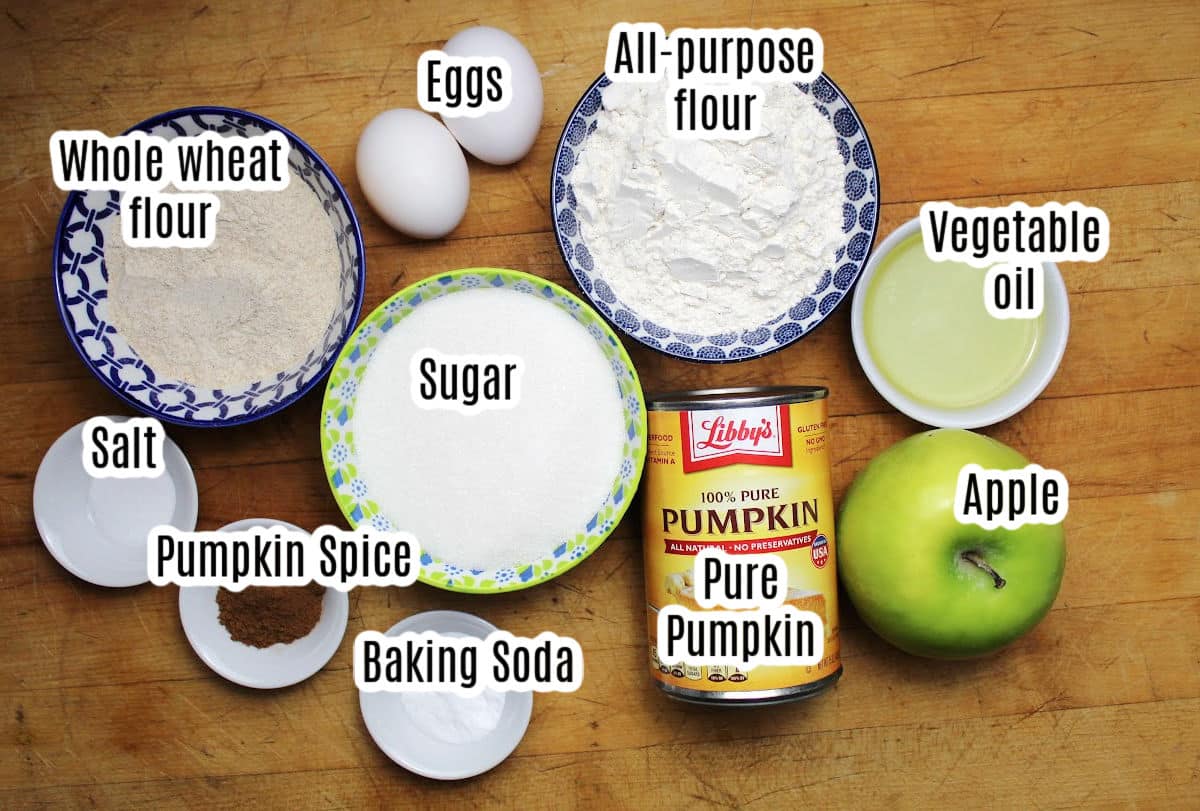pumpkin apple muffin ingredients including flour, eggs, sugar, can of pumpkin, vegetable oil, apple, pumpkin spice, baking soda and salt. 