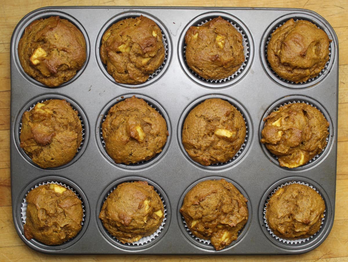 12 pumpkin apple muffins in a muffin tin. 