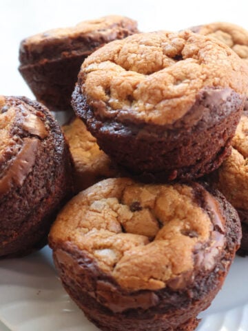 Brookies on a white plate. Brookies are brownie on the bottom, cookies on the top. Baked in a muffin tin.