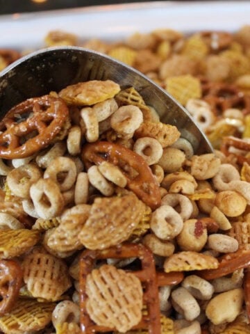 Chex mix being stirred with a big spoon