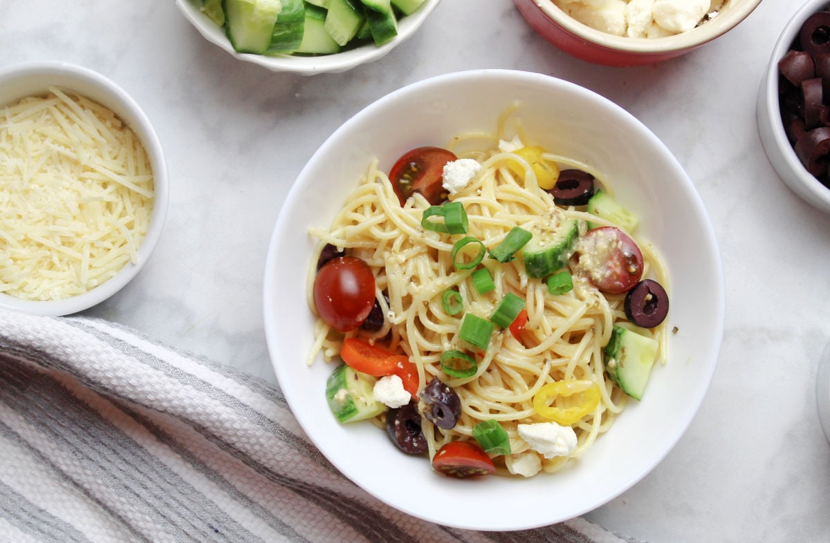 Italian themed pasta salad using spagetti noodles, tomatoes, olives, cucumbers and Italian dressing.