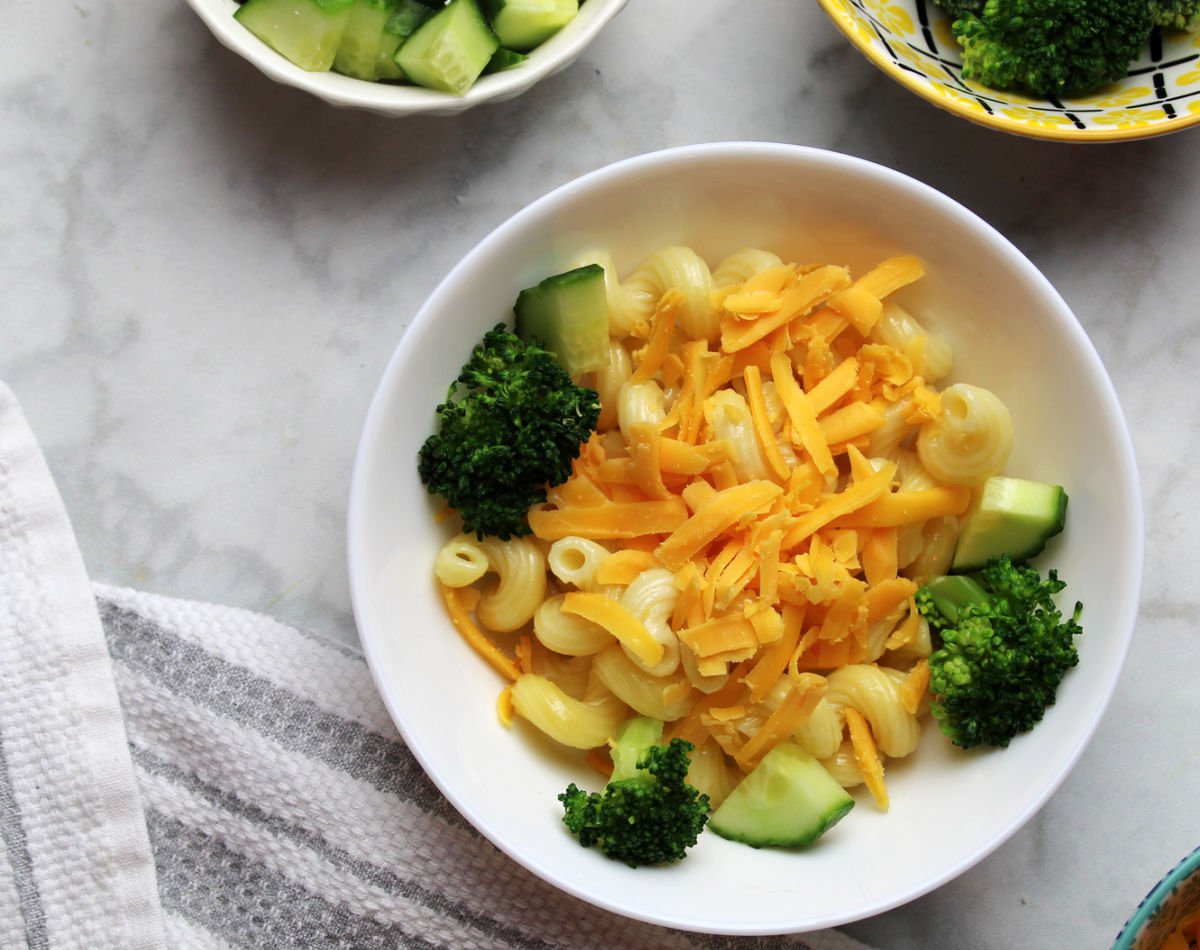 Pasta bowl suggestion for picky eaters.  It includes pasta, shredded cheddar cheese and steamed broccoli.