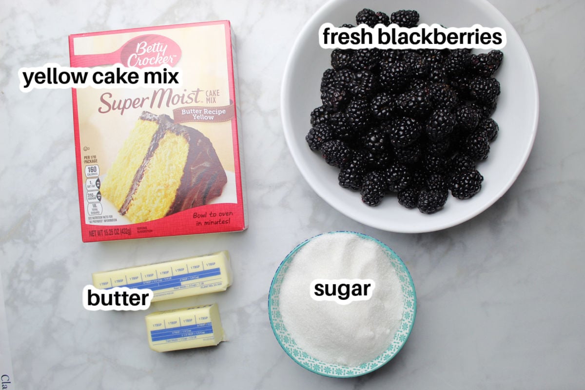 Blackberry dump ingredients including fresh blackberries, yellow boxed cake mix, butter and sugar.