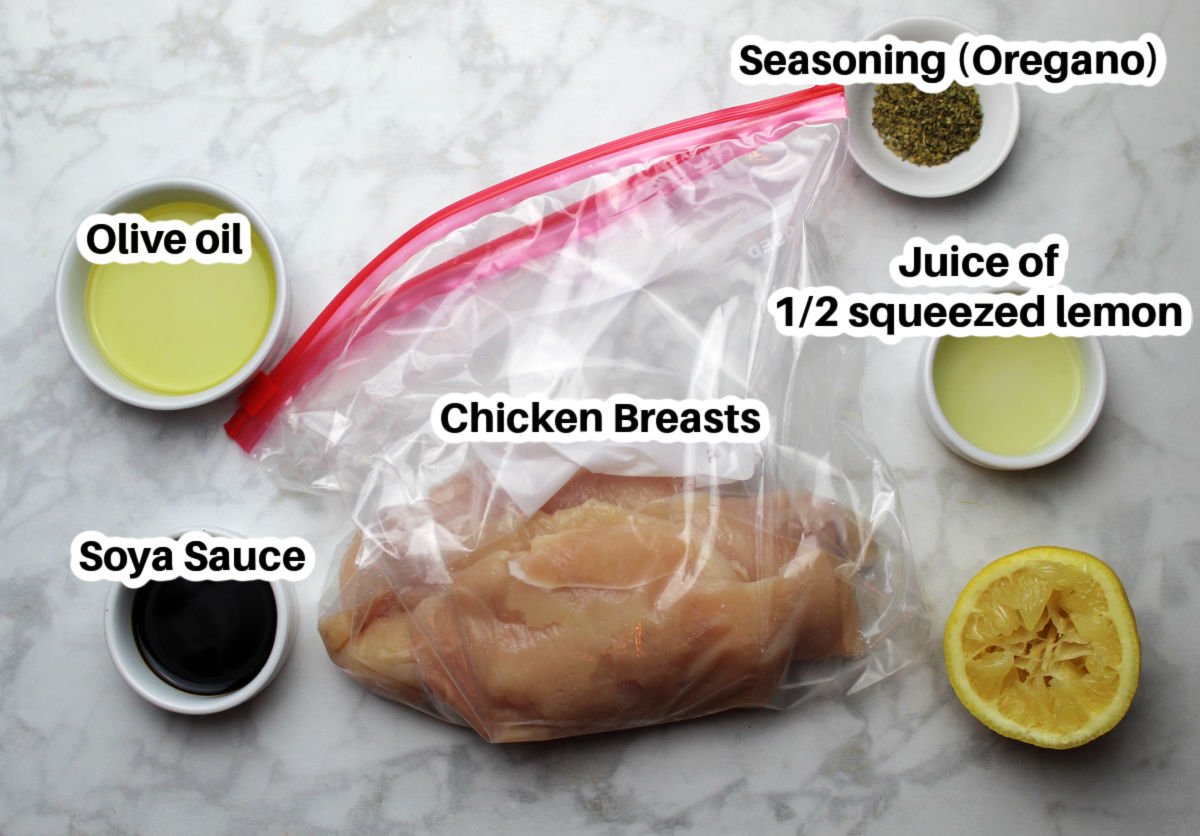 Ingredients for chicken marinade includes 4 thin chicken filets in a bag, small containers of remeasured olive oil, soy sauce, juiced lemon and oregano.