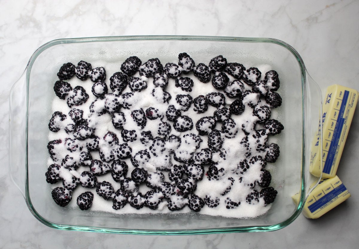 sugar spread on fresh blackberries in baking dish.
