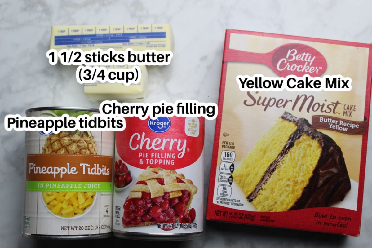 Ingredients to make cherry pineapple dump cake.  1 ½ sticks of butter, a box of yellow cake mix, a can of pineapple tidbits and a can of cherry pie filling.
