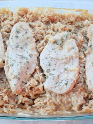 4 pieces of cooked and seasoned chicken pieces on top of cooked and creamy seasoned rice