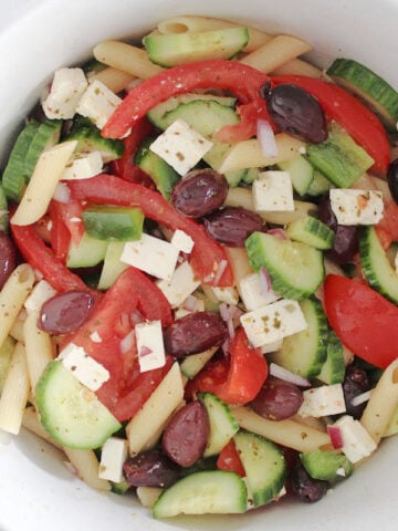 Greek Pasta salad with cut up tomoatoes, cucumbers, feta, red onions, olives and a fresh oregano, lemon with olive oil dressing.