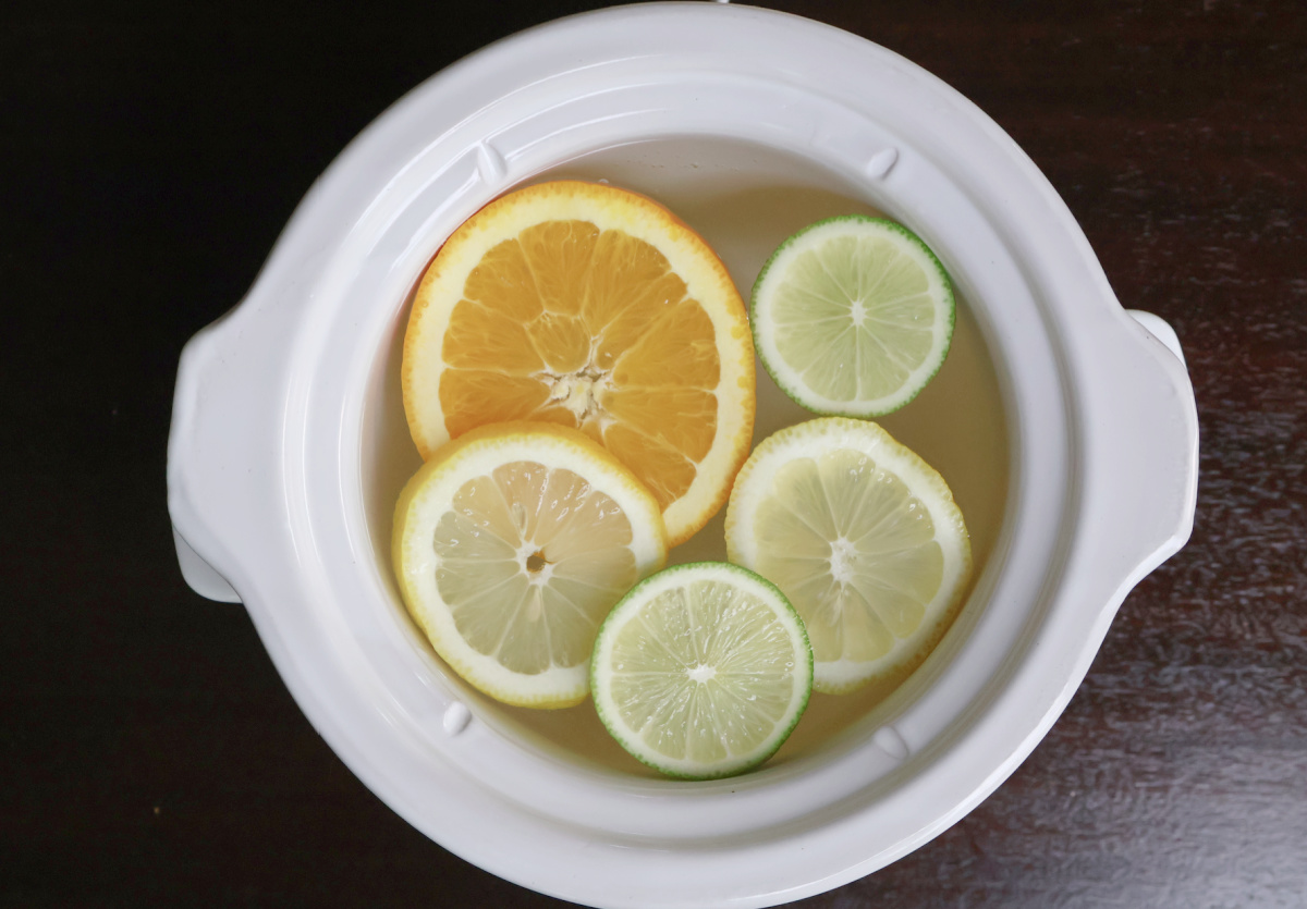 White simmer pot with slices of orange, lemon and lime.