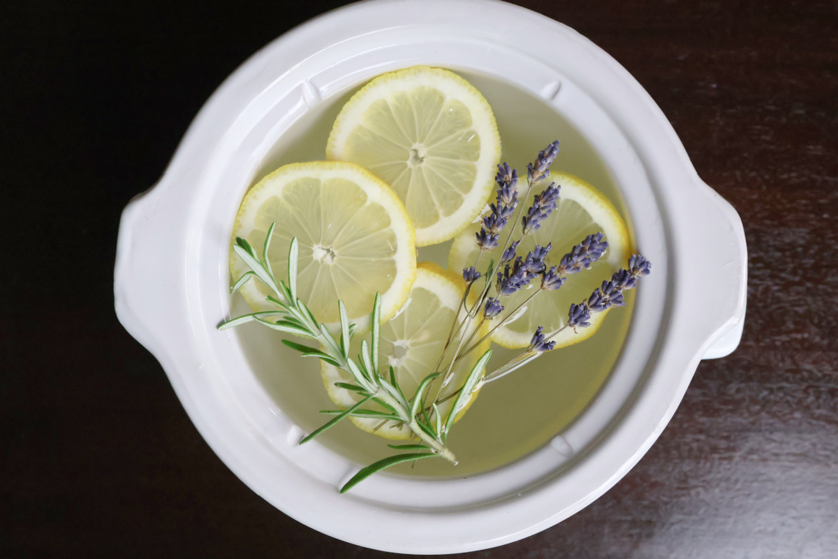 white simmer pot with sliced lemon, rosemary and lavender.