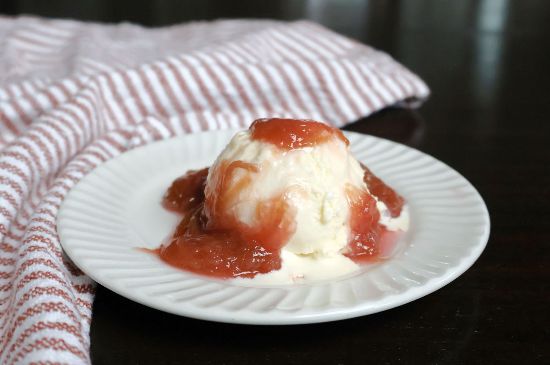 rhubarb sauce on a scoop of vanilla ice cream