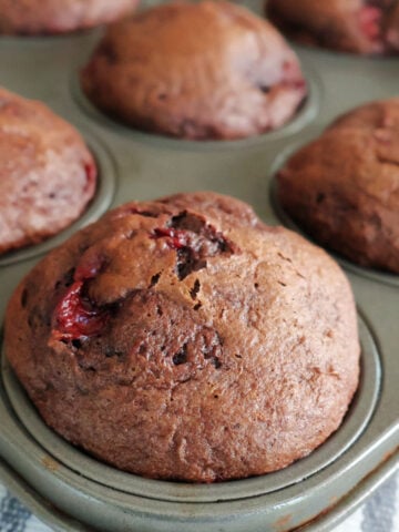 baked chocolate cherry muffins in a muffin tin.