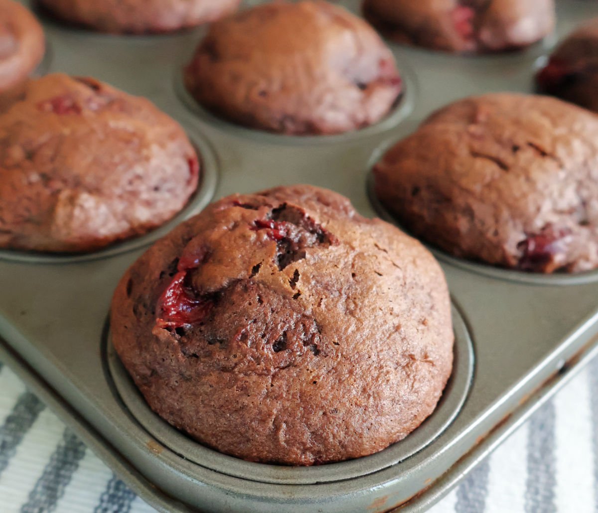 baked chocolate cherry muffins in a muffin tin.