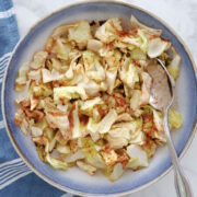 Air fried cabbage, seasoned with paprika for some color, in a white and blue bowl.