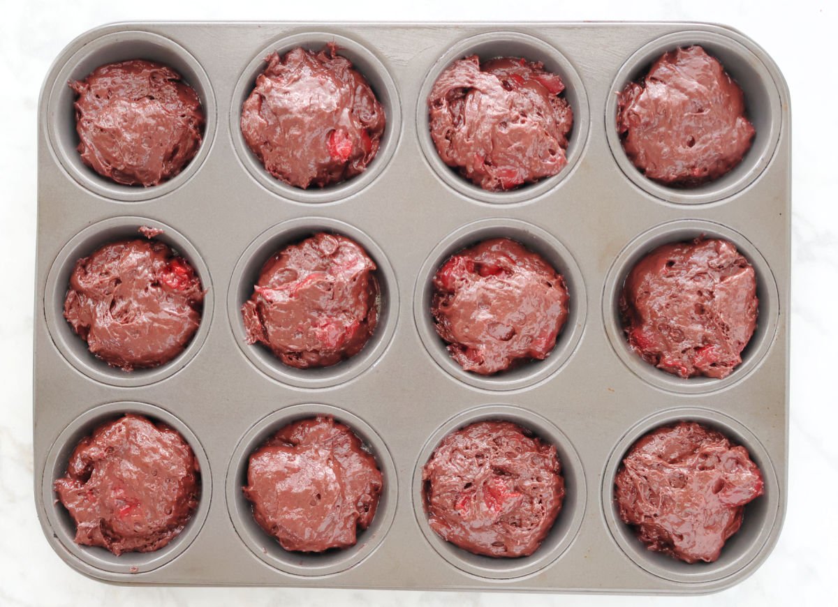 chocolate cherry muffin batter in muffin tin.