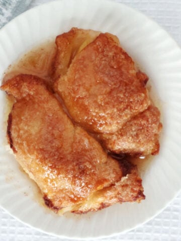 two peach dumplings with a light coating of a sweet buttery sauce.