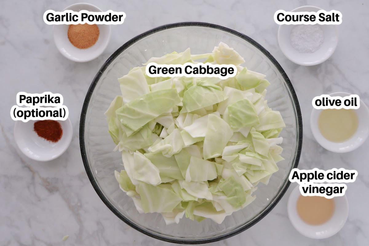 Ingredients for air fryer cabbage includes chopped green cabbage, apple cider vinegar, olive oil, garlic powder, salt and optional paprika