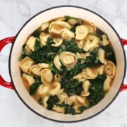 Spinach tortellini soup in a red pot. Resulting soup took 15 minutes