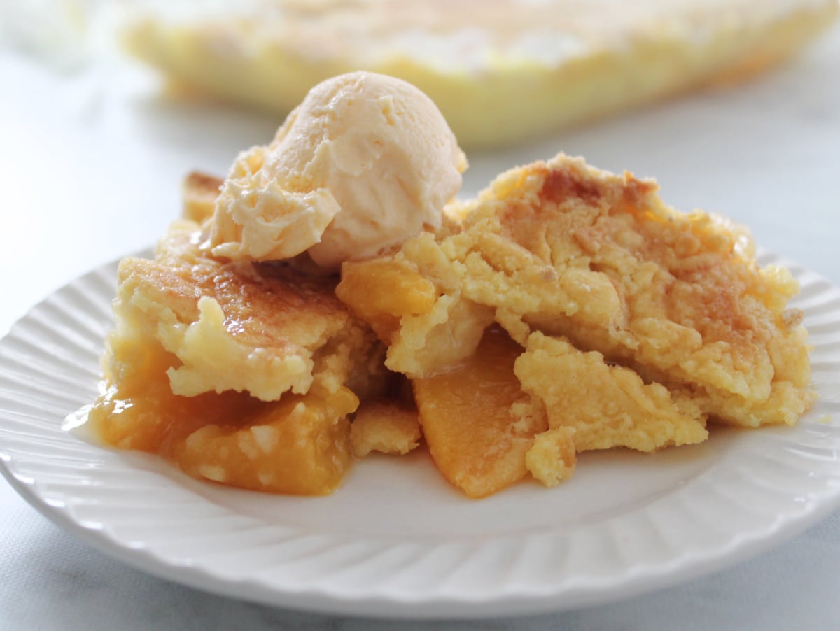 a scoop of ice cream on top of an easy 3 ingredient peach cobbler /crisp.