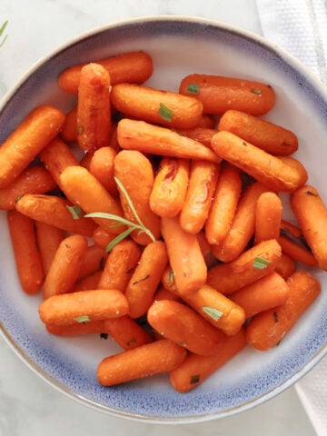 Roasted Honey Baby Carrots in a blue and white bowl.