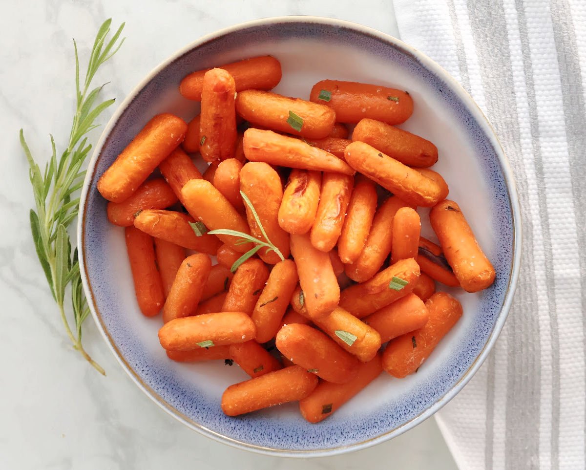 Roasted Honey Baby Carrots in a blue and white bowl.