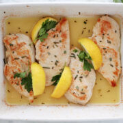 baked rosemary chicken in a butter, lemon and chicken broth. Garnished with lemon wedges, sprinkle of fresh minced rosemary and sprigs of parsley.