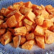 Air fried sweet potato cubes on a blue dish.