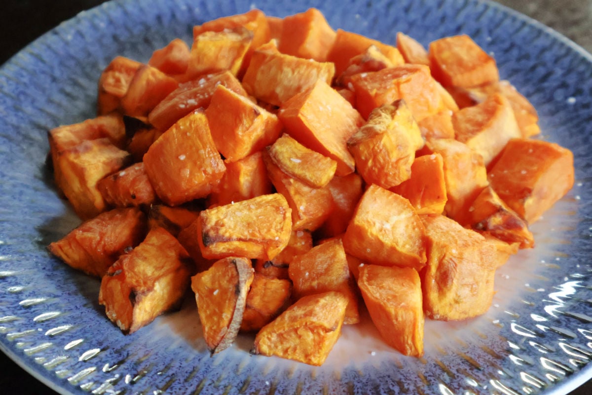 Air fried sweet potato cubes on a blue dish.