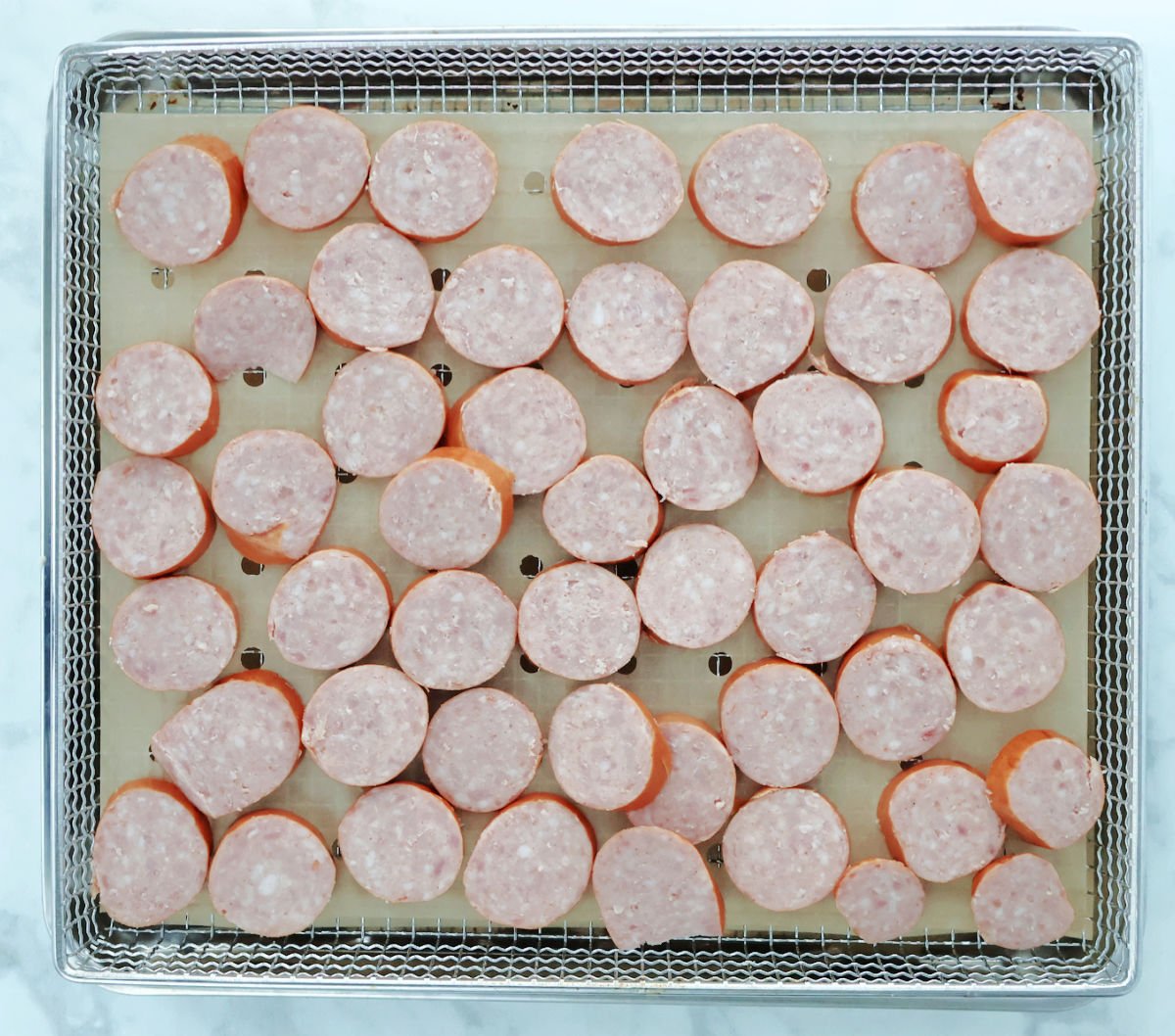 kielbasa cut into coins and placed evenly on air fryer basket.