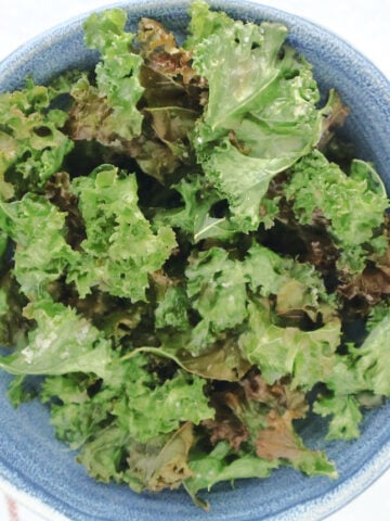 air fried kale pieces in a blue bowl