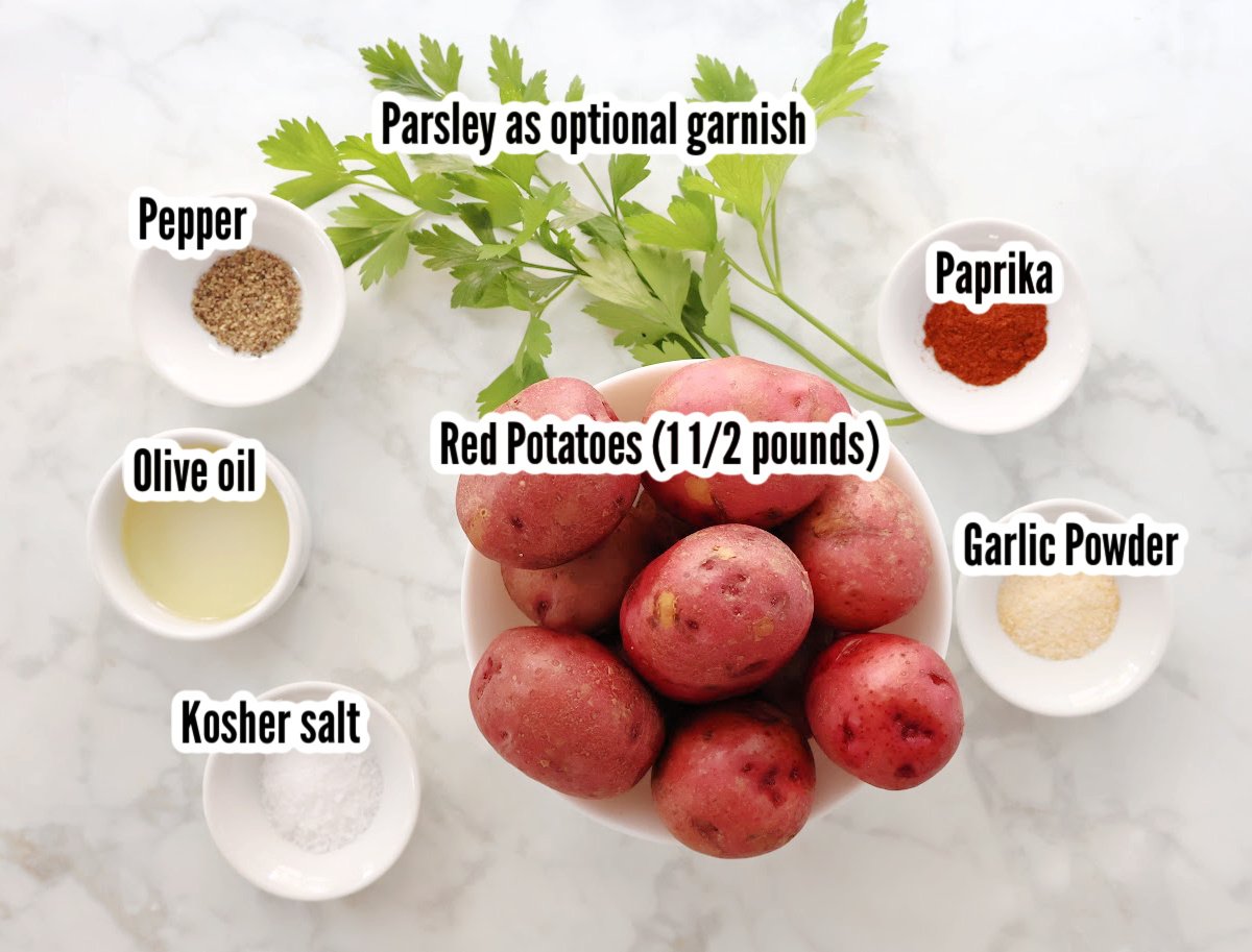 Air fryer roasted red potatoes includes red potatoes, salt, pepper, paprika, garlic powder, olive oil and parsley as a garnish.