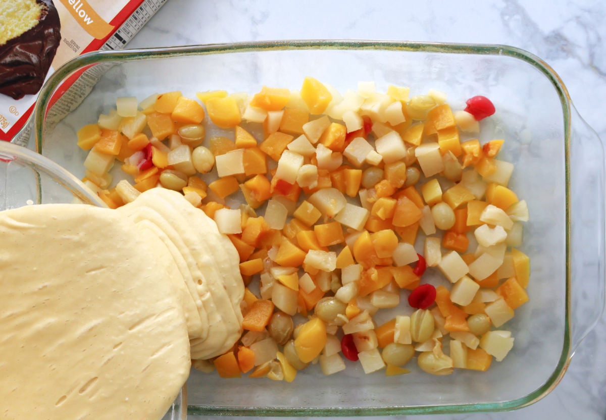 pouring the cake batter on the layer of fruit cocktail.