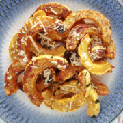 Sliced and air fried delicata squash with italian herb seasoning and parmasan cheese sprinkled on top.