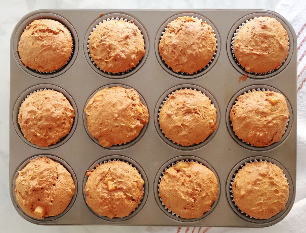 a dozen carrot muffins in a muffin tin. 