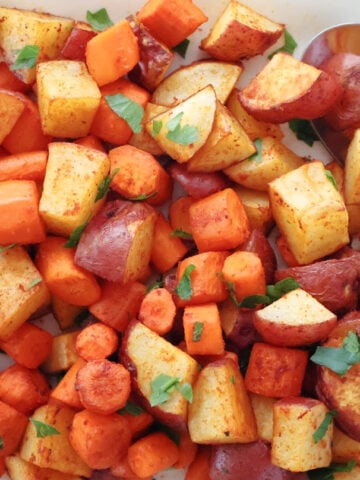 Red potatoes and carrots ready to be served. They are oven browned with the smoked paprika seasoning visible.