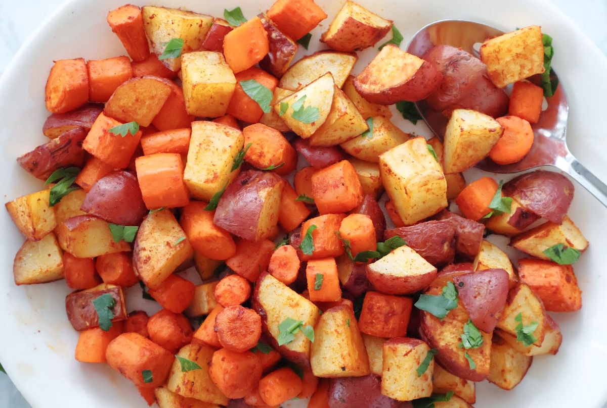 Red potatoes and carrots ready to be served. They are oven browned with the smoked paprika seasoning visible.