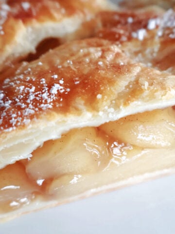 A cut piece of apple strudel so you can see the apple filling.