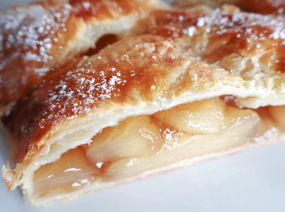 A cut piece of apple strudel so you can see the apple filling.