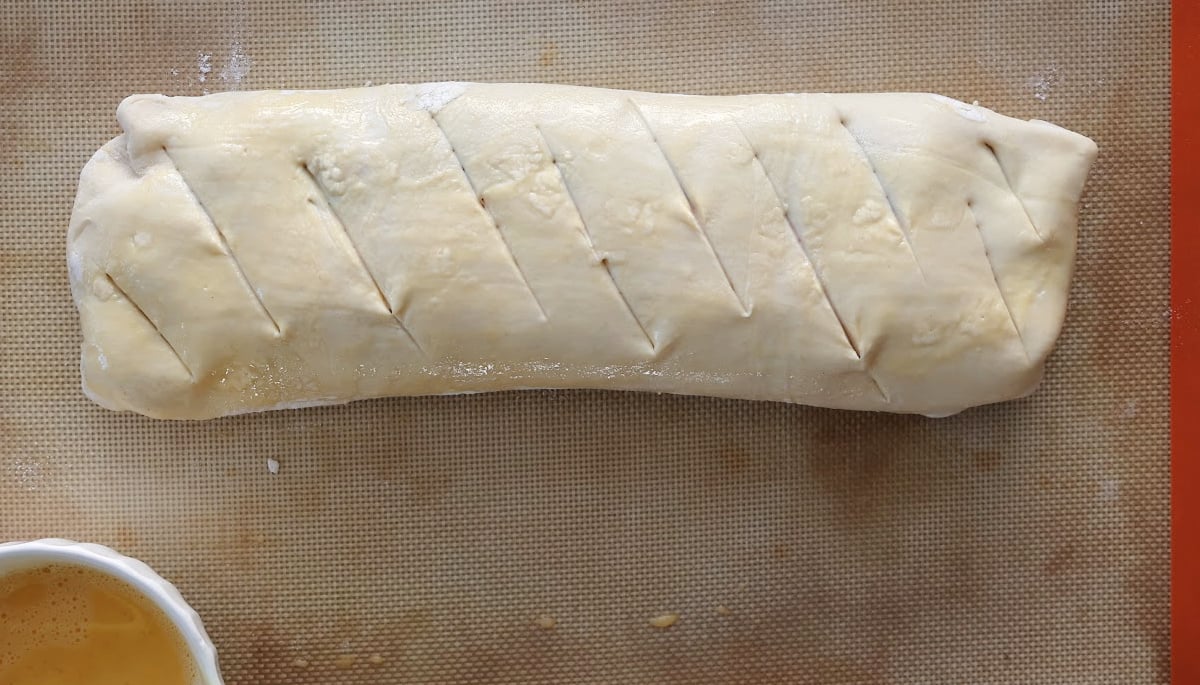 Cherry strudel ready for the oven.  Slits have been cut into the strudel and an egg wash aplied.