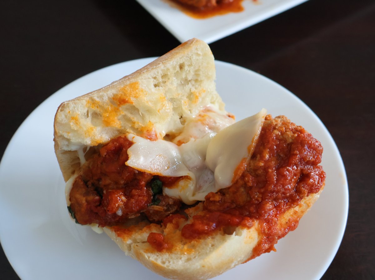 Ingredients for ricotta meatballs in a bowl. Ingredients include ground pork, ground beef, ricotta cheese, parmigiano cheese, Italian bread crumbs and eggs.