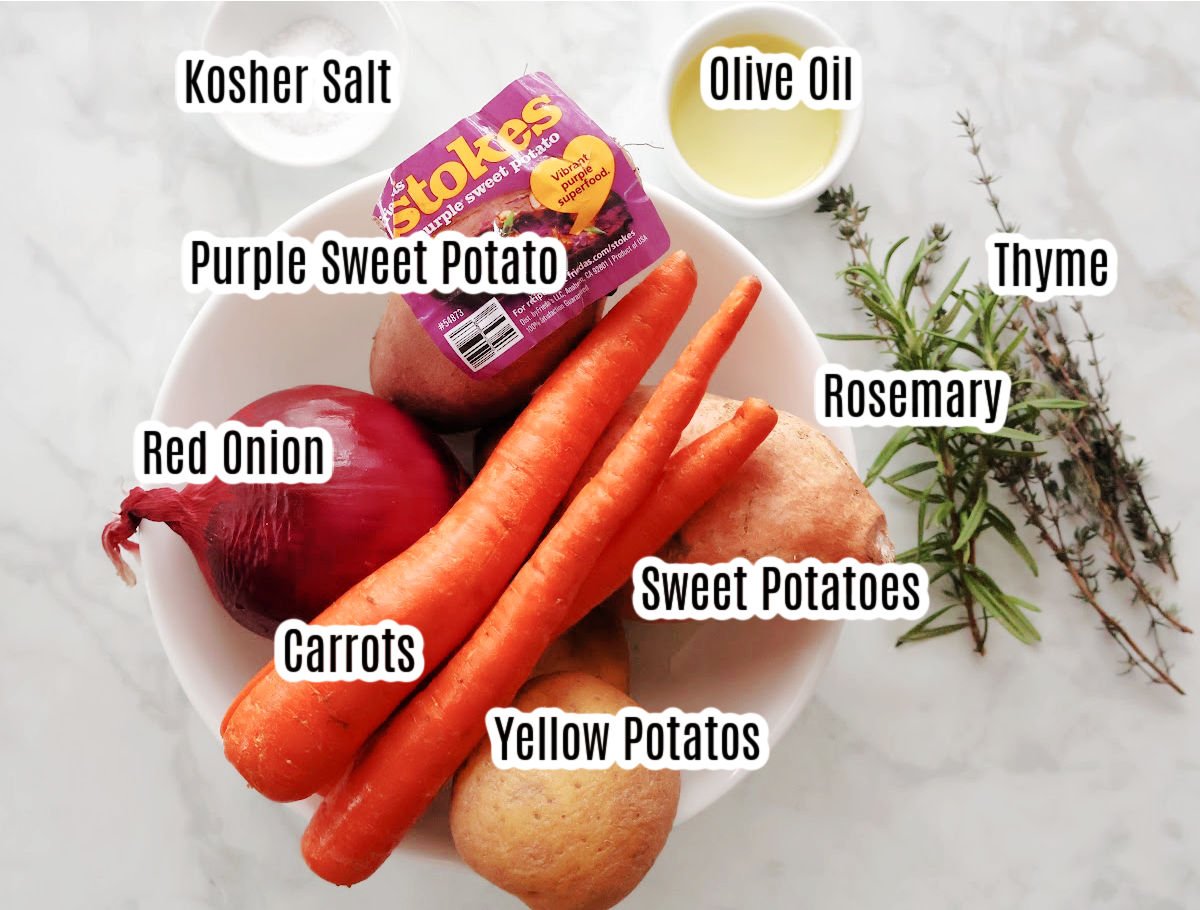 labeled ingredients for oven roasted root vegetables.  Includes potatoes, sweet potatoes, purple sweet potatoes, carrots, and red onion.  Oil, kosher salt thyme and rosemary are also shown.