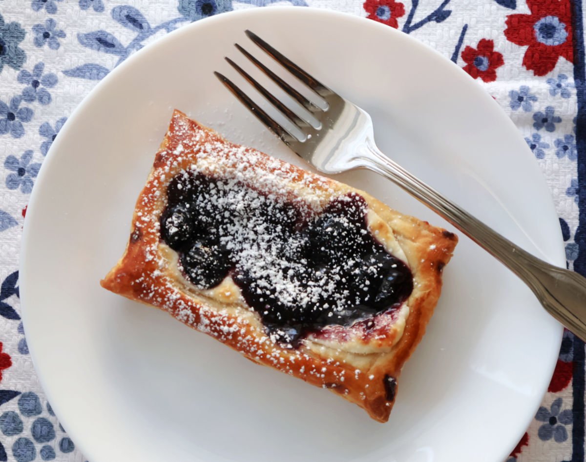 blueberry cheese danish with a srinkle of powdered sugar.