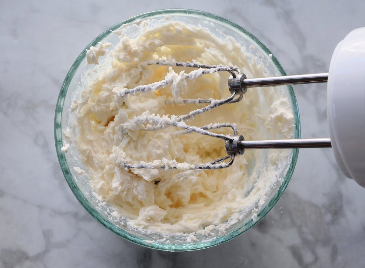 cream cheese and granulated sugar mixed until fluffy in a glass bowl.