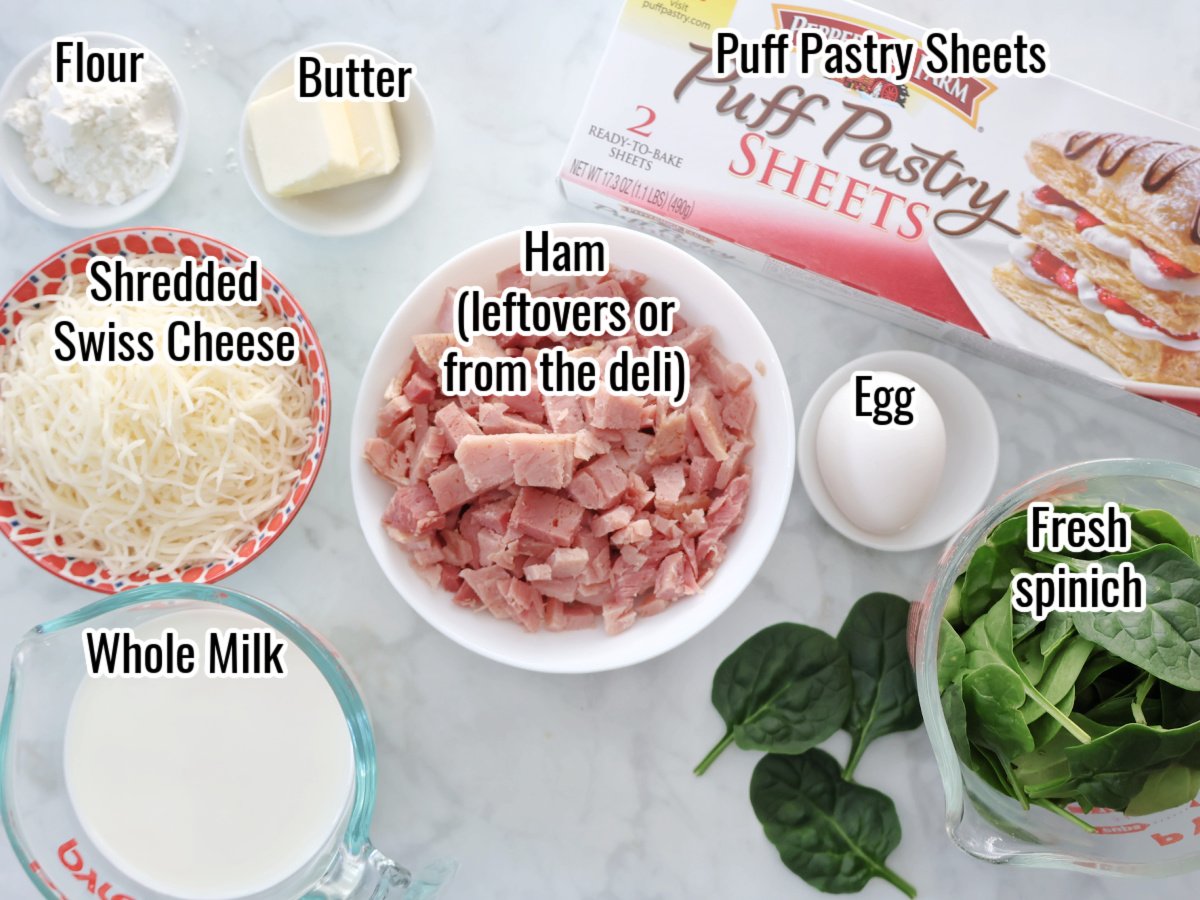 Ingredients for ham and cheese puff pastry.  includes puff pastry sheets, levtover ham, egg, butter, shredded cheese, milk, egg and spinach.