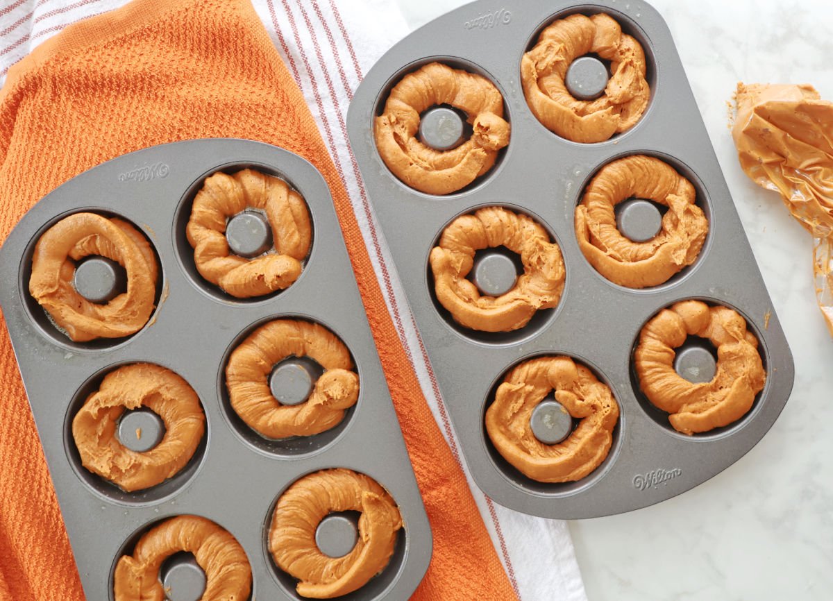 Donut pan filled with pumpkin spice batter before baking