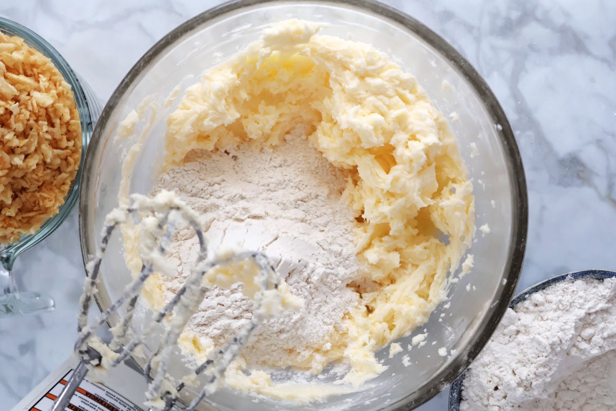Flour being added to creamed butter and sugar